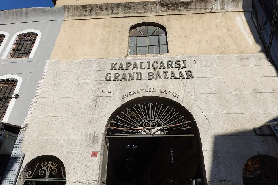 İstanbul Kapalıçarşı’nın Kürkçüler Kapısı: taş cephede “Kapalıçarşı Grand Bazaar” yazısı ve kemerli giriş